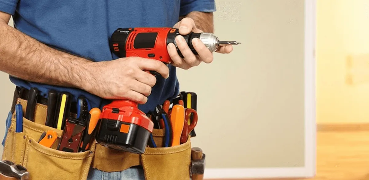 Handyman holding a power drill for home repairs and installations in Irvine, CA